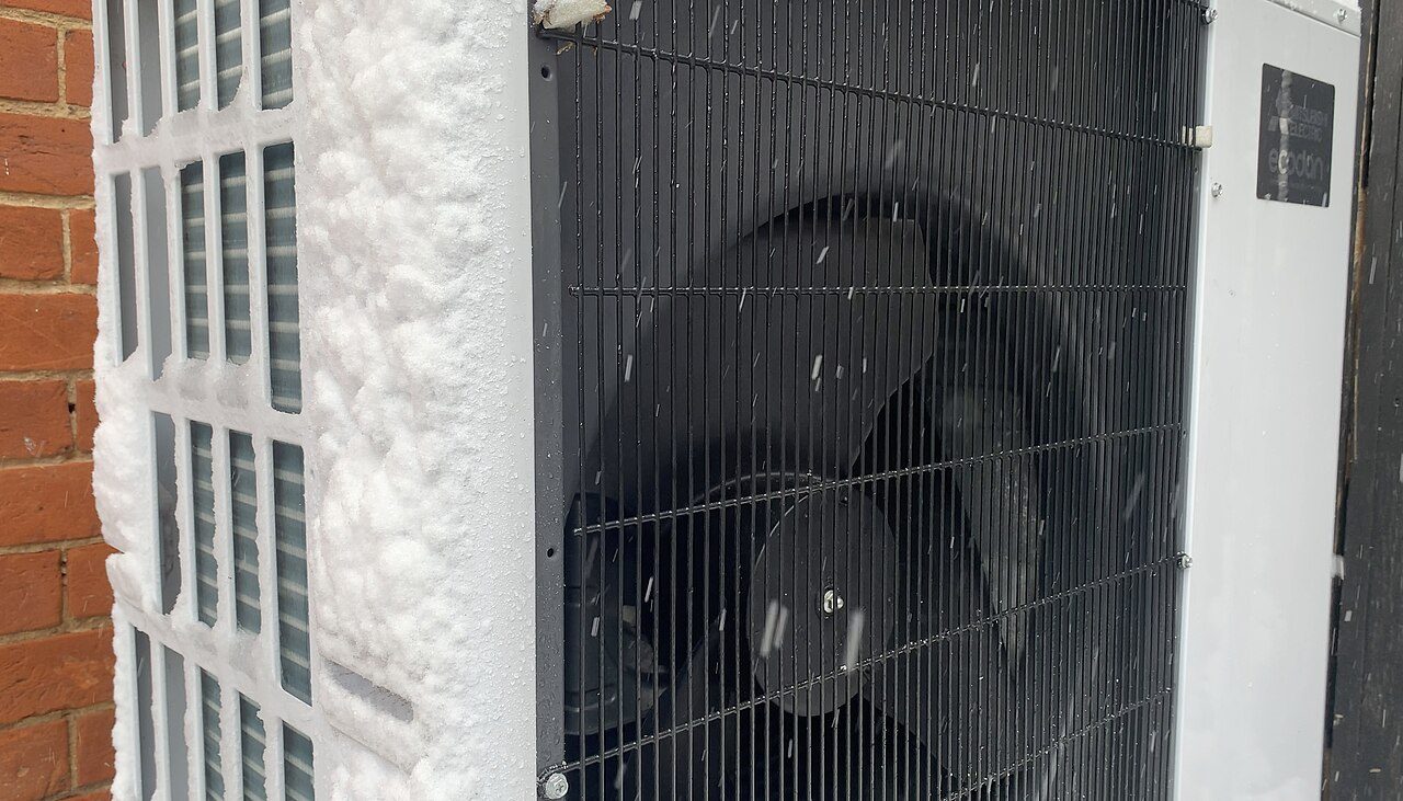 An outdoor air-source heat pump unit in winter conditions. Representative equipment, not an installation by a listed partner.
